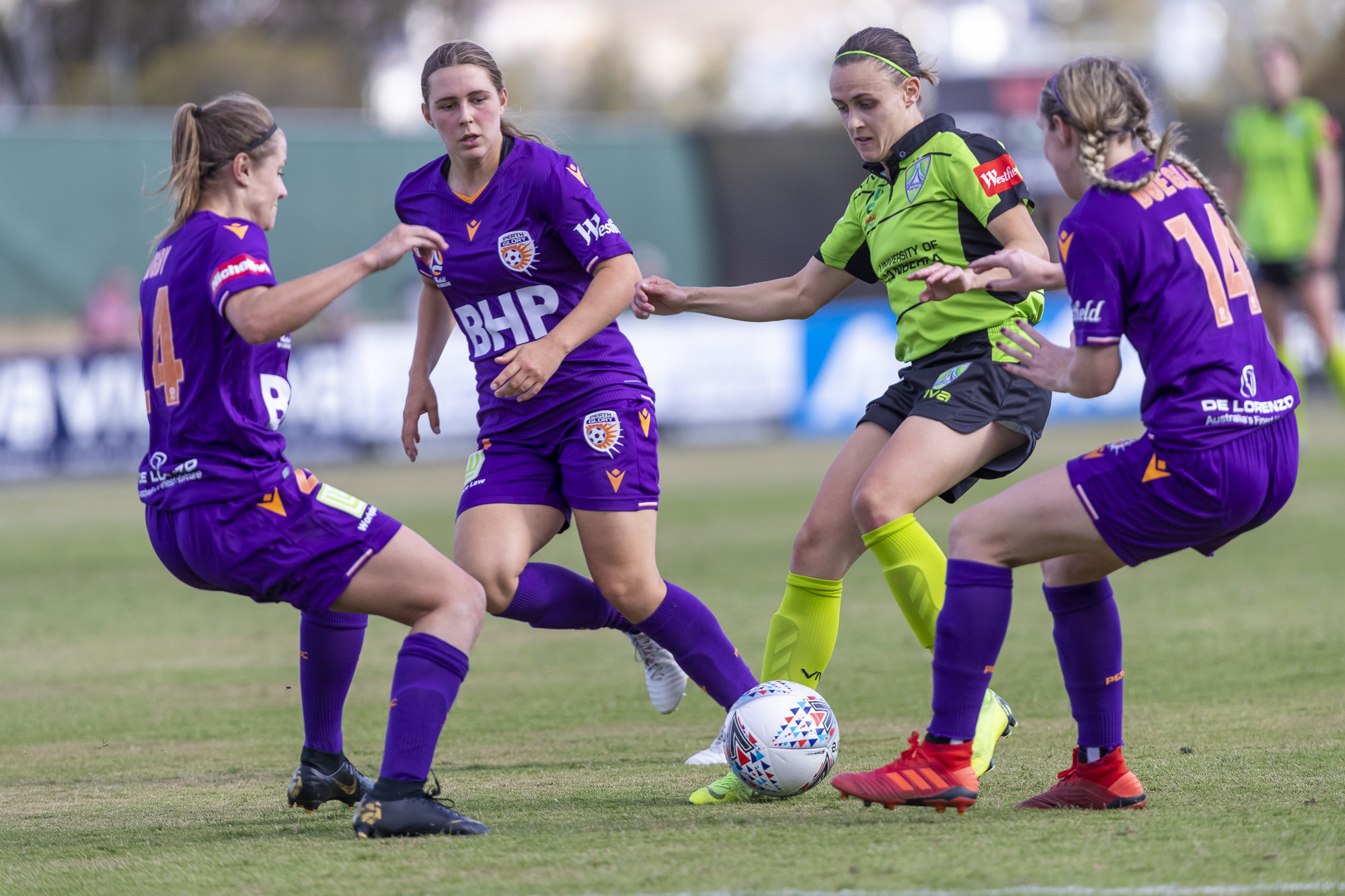 Olivia Price is closed down by Perth Glory midfielders. 